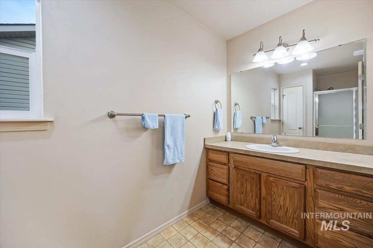 Full bathroom with vanity and a stall shower
