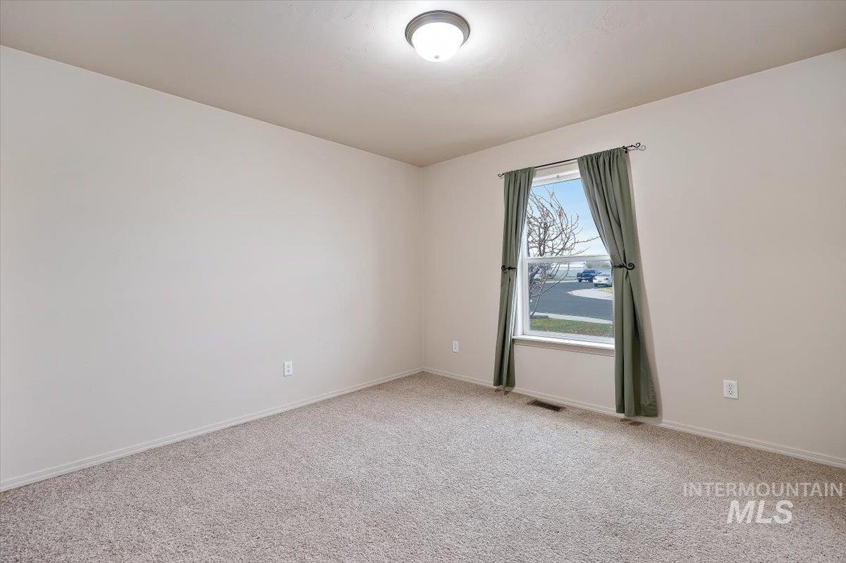 Carpeted spare room with baseboards