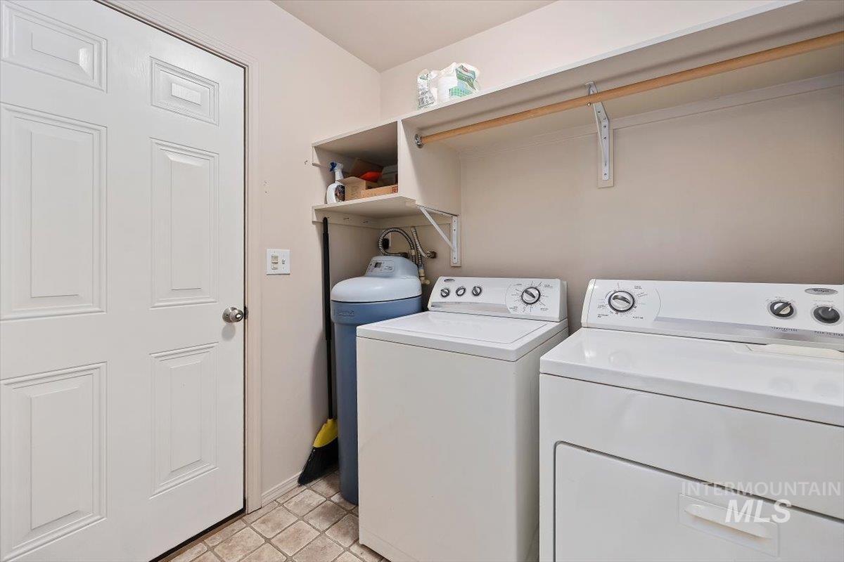 Laundry area with washing machine and dryer and light tile patterned floors
