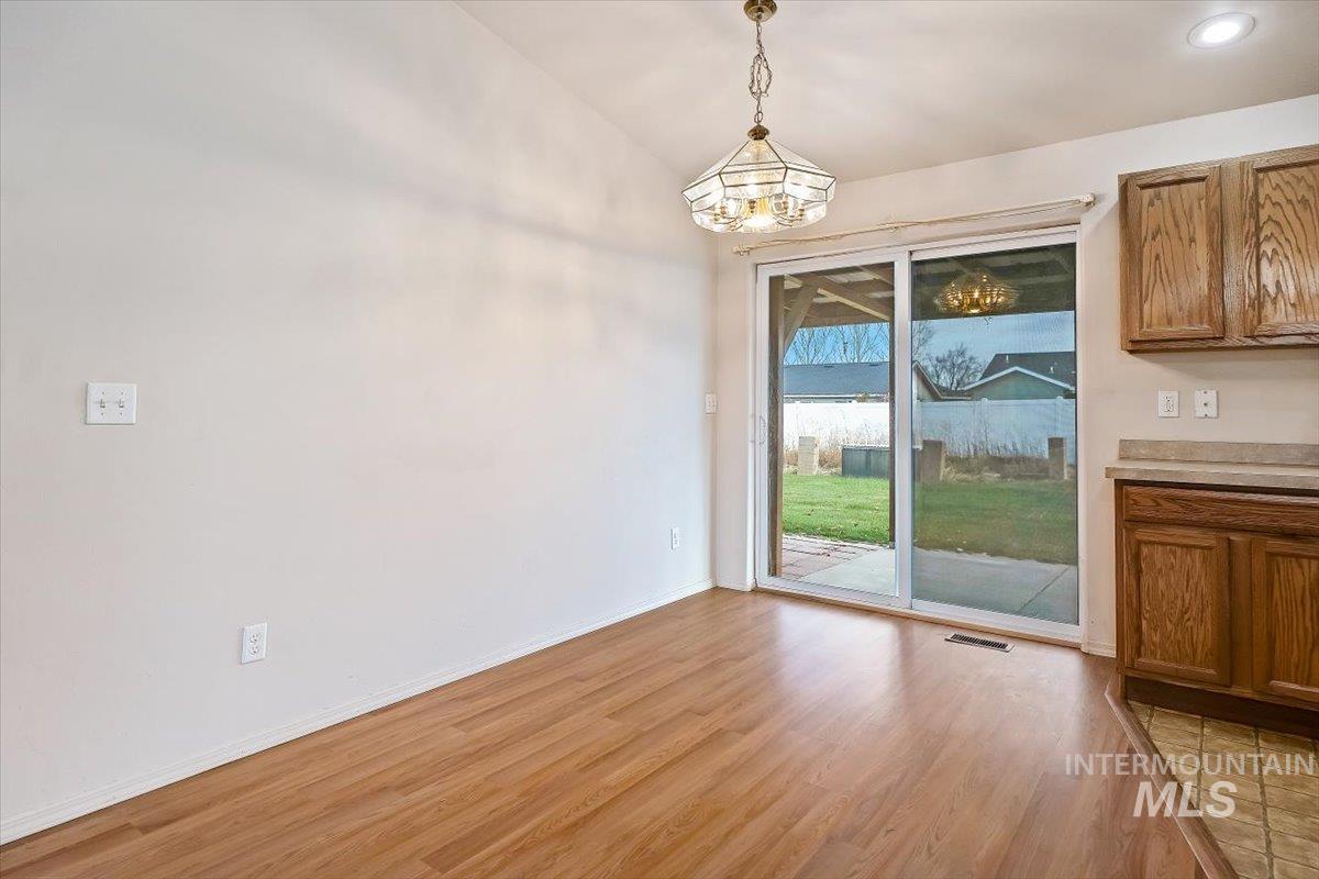 Unfurnished dining area with light wood-type flooring and a chandelier