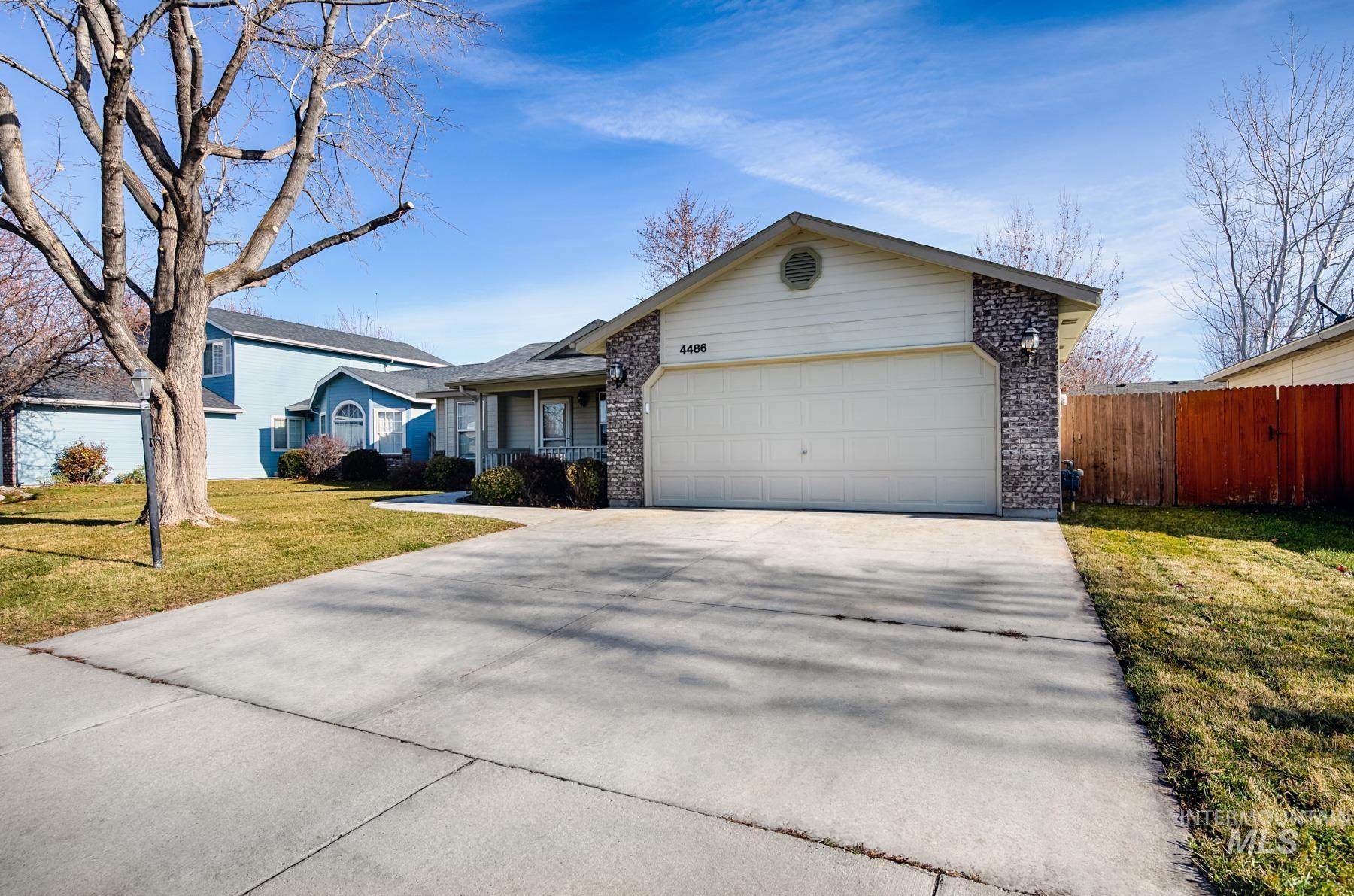 Ranch-style house featuring concrete driveway, brick siding, and a garage