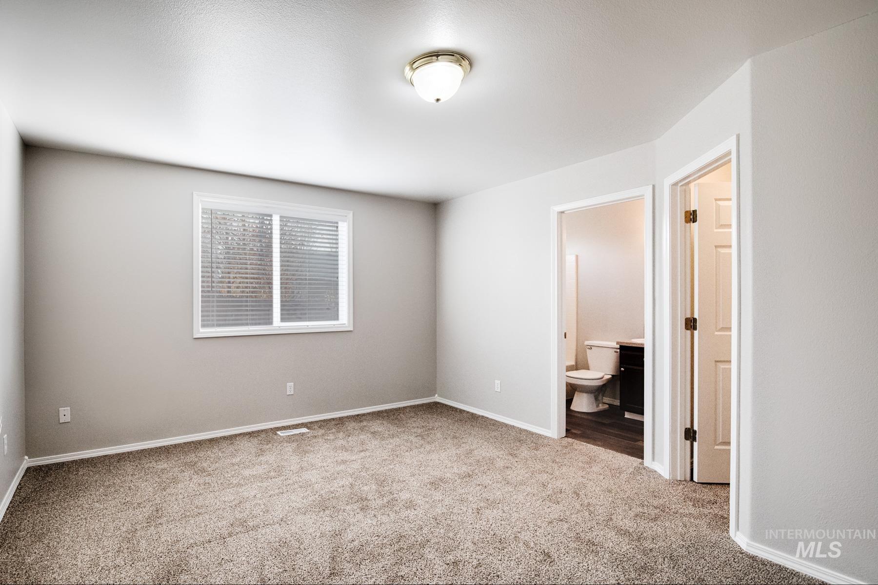 Unfurnished bedroom featuring carpet and connected bathroom