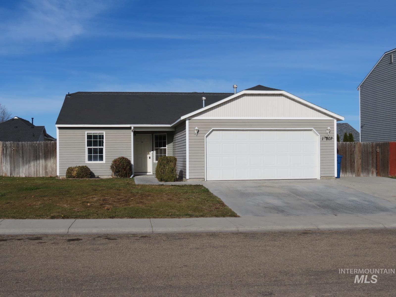 Ranch-style house featuring driveway and a garage