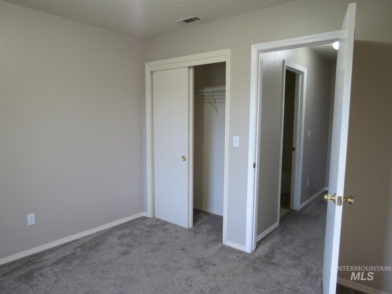 Bed #2. Unfurnished bedroom with carpet flooring, a closet, and a textured ceiling