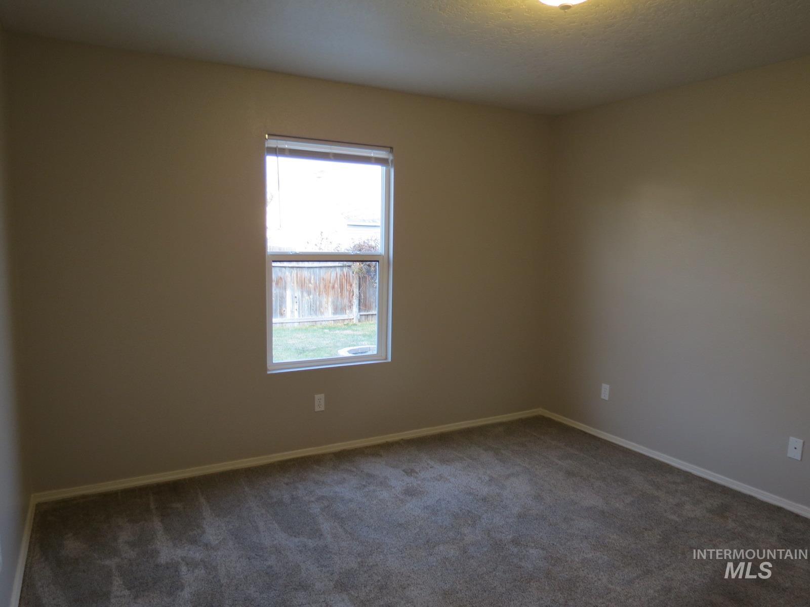 Unfurnished room with carpet flooring and a textured ceiling