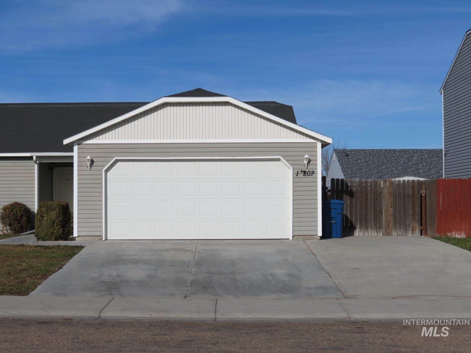Ranch-style house featuring concrete driveway and a garage