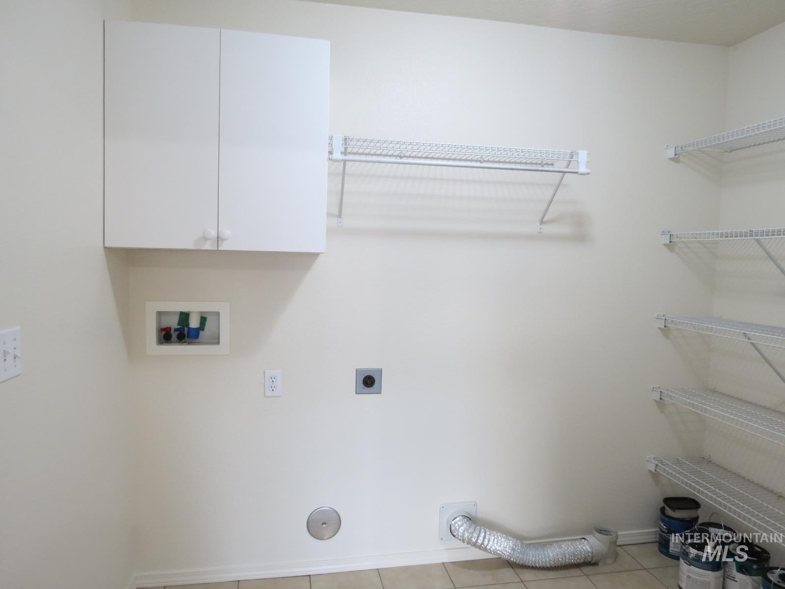 Laundry room featuring washer hookup, hookup for an electric dryer, cabinet space, and light tile patterned floors