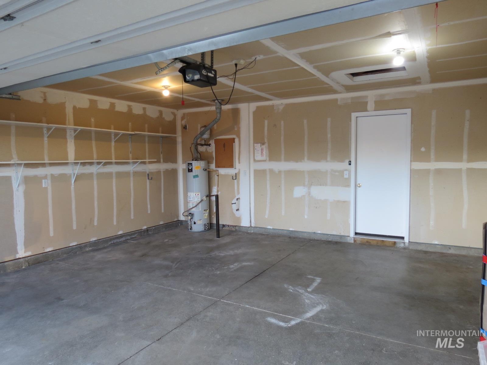 Garage featuring secured water heater and a garage door opener