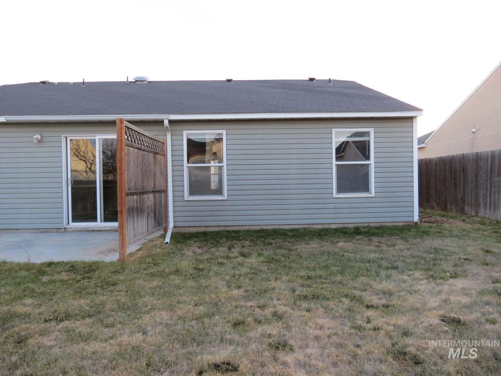 Rear view of property featuring roof with shingles and a patio area