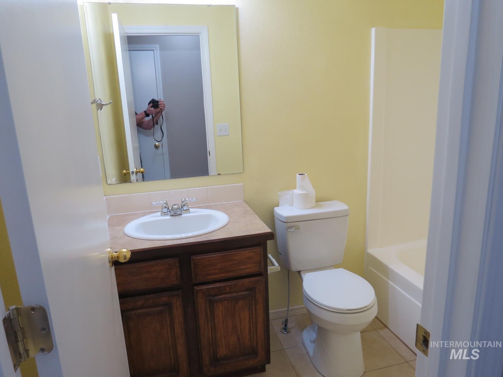 Bathroom with vanity, light tile patterned floors, and  shower combination