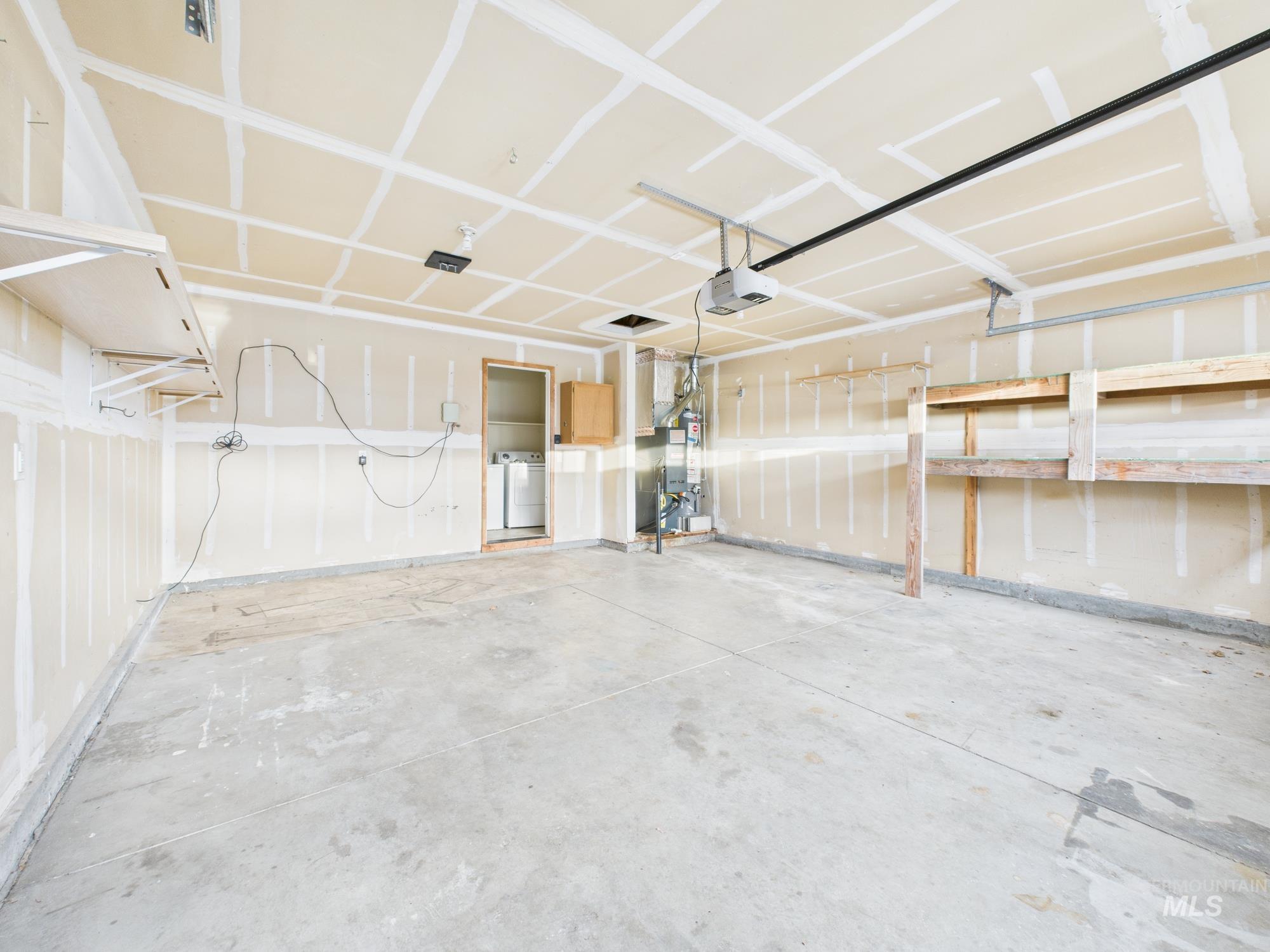 Garage with a garage door opener and washer / clothes dryer