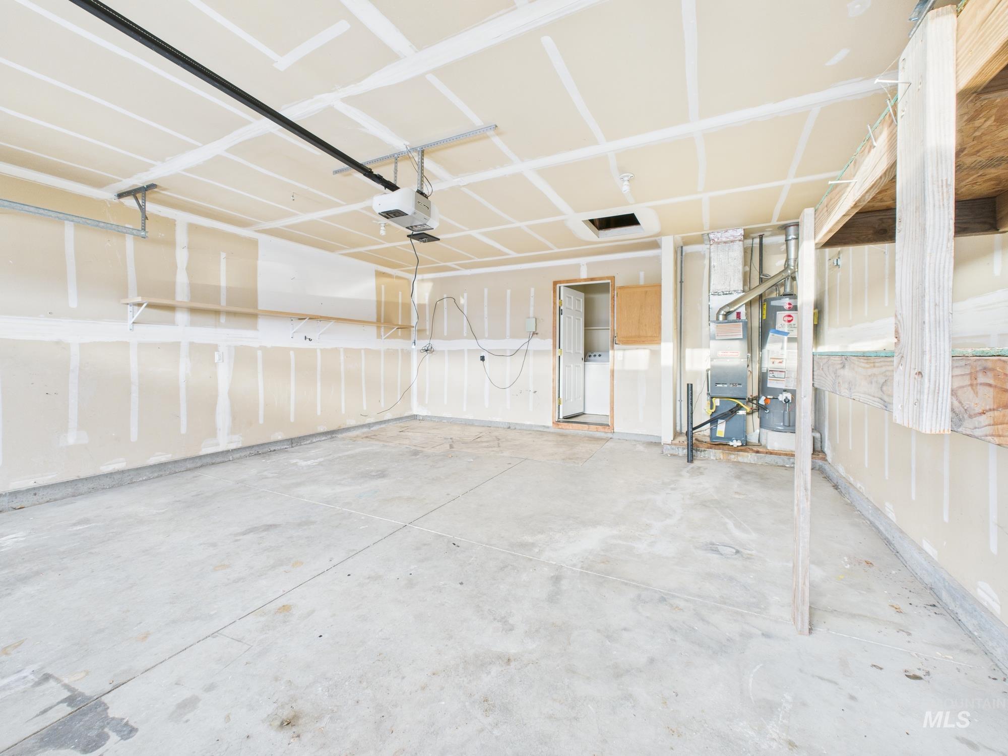 Garage featuring a garage door opener and water heater