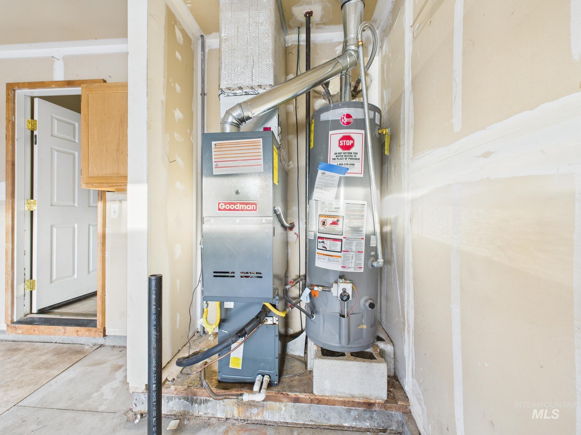 Utility room featuring water heater and heating unit
