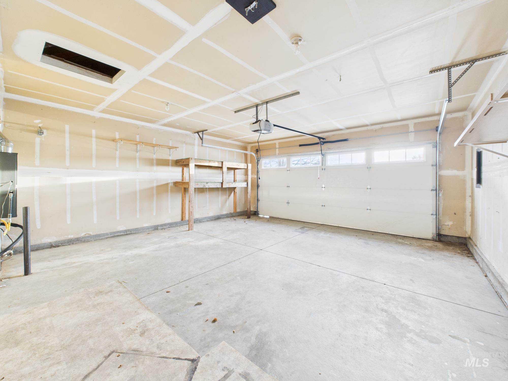 Garage featuring electric panel and a garage door opener