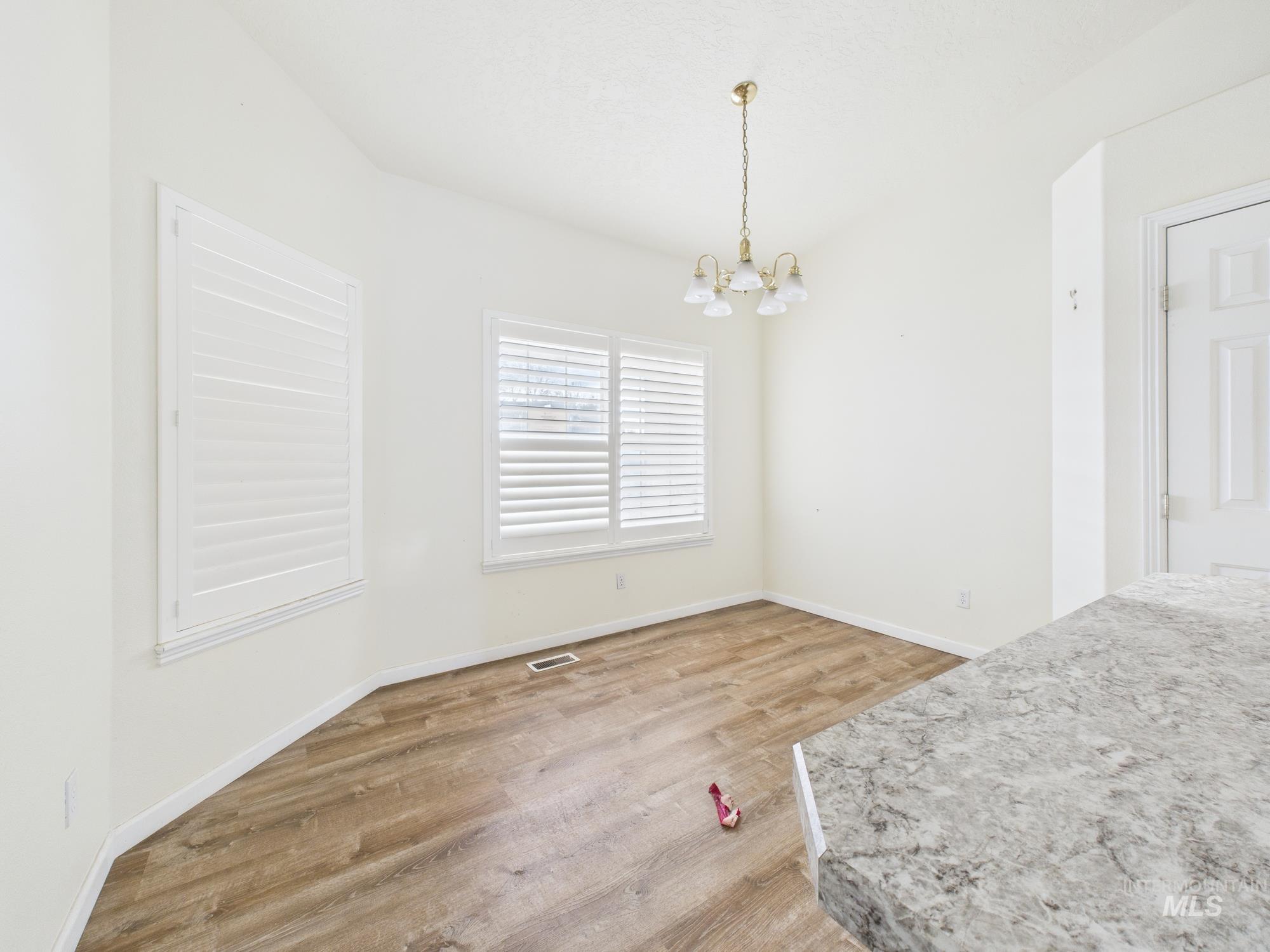 Unfurnished dining area featuring light wood-style floors and a chandelier