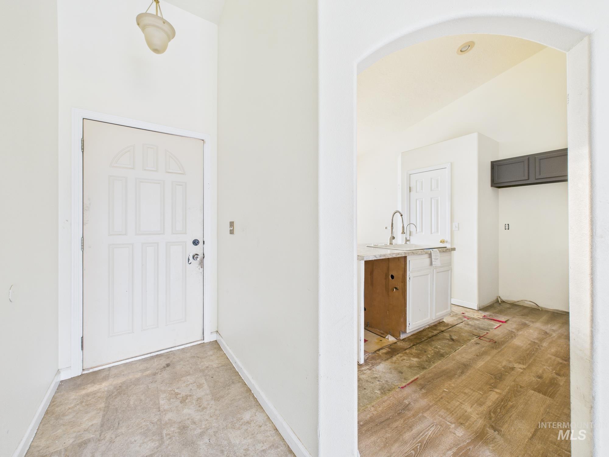 Entryway with baseboards and arched walkways
