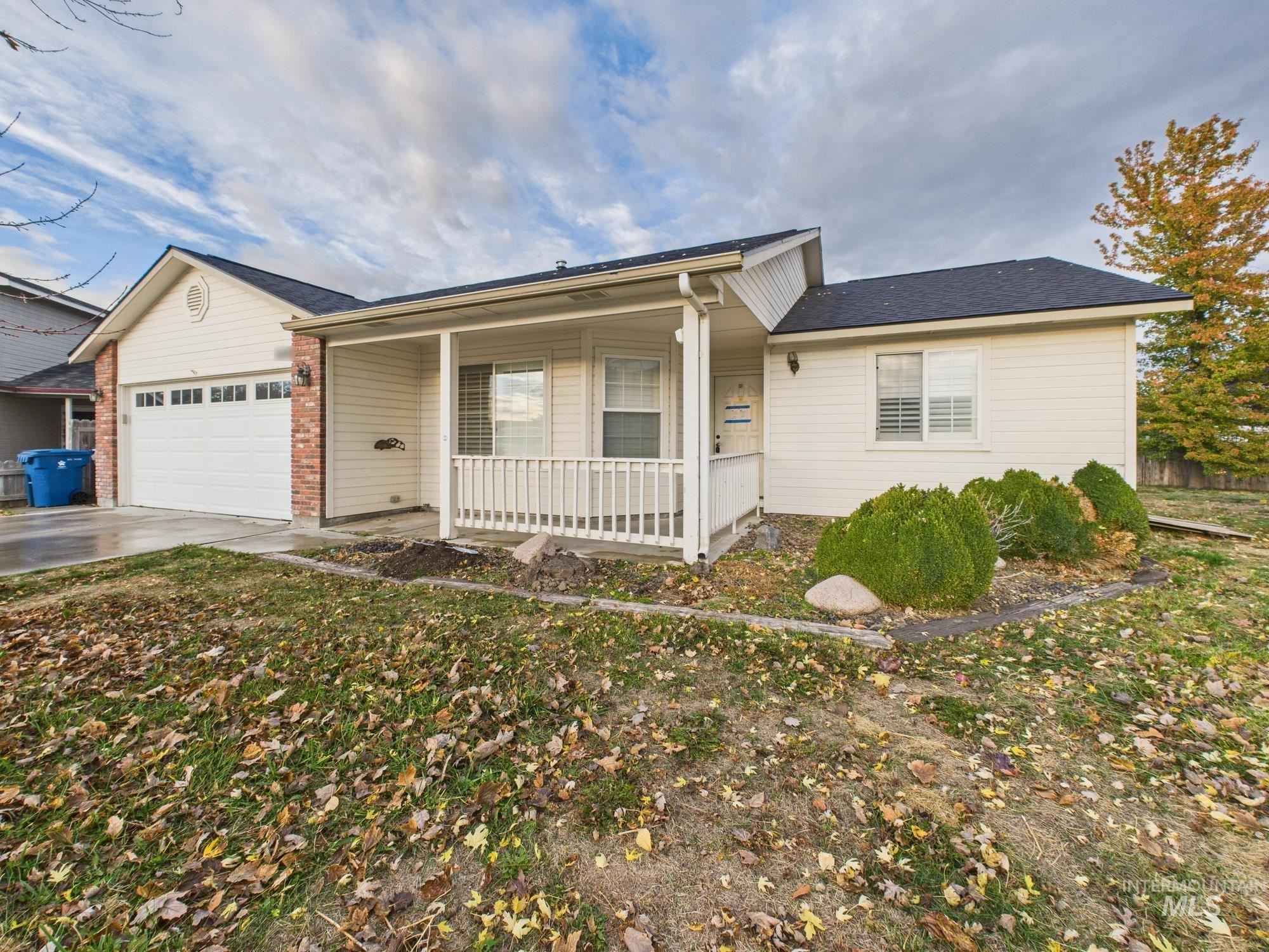 Single story home featuring concrete driveway, an attached garage, covered porch, and brick siding