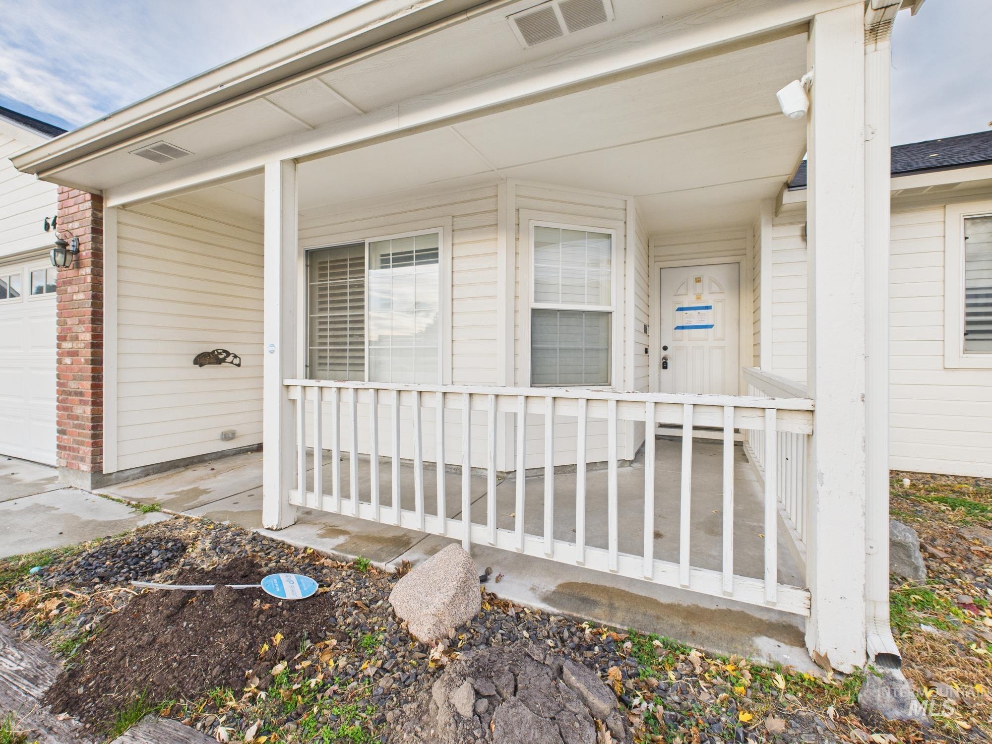 View of exterior entry with covered porch and an attached garage