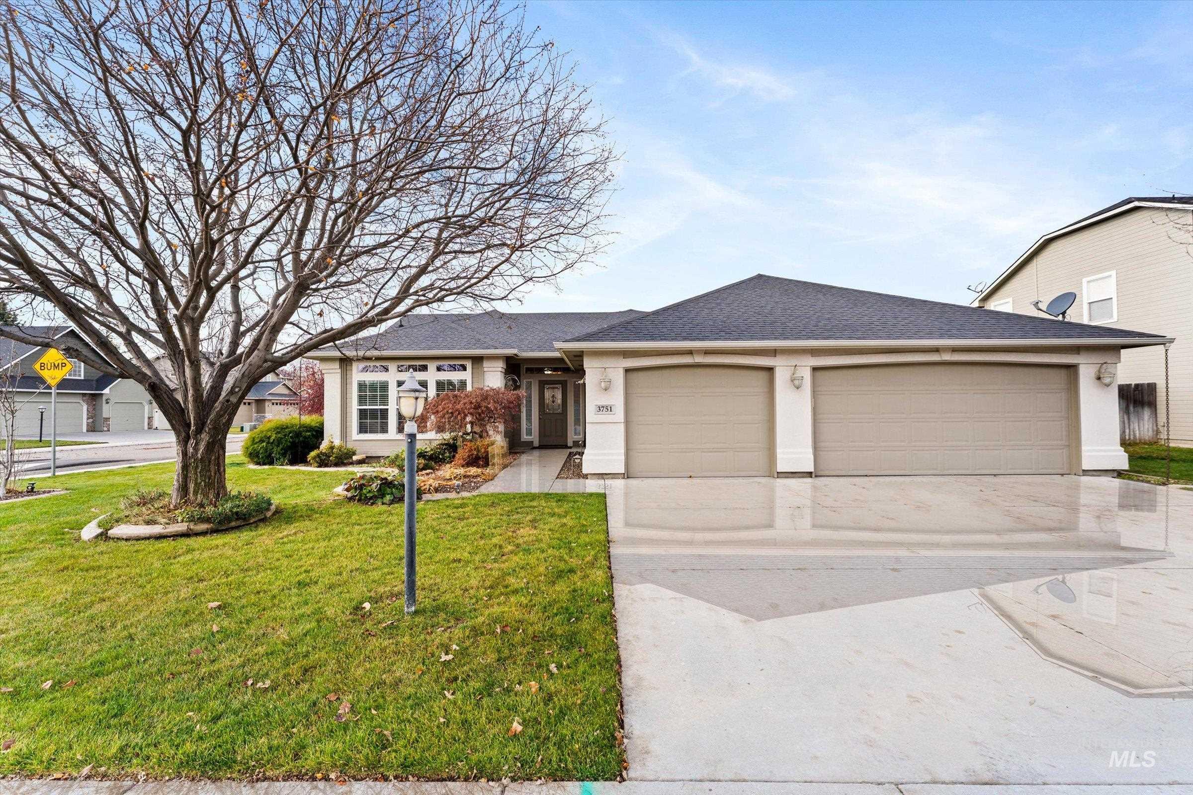 Ranch-style home featuring driveway, a front lawn, a shingled roof, and a garage