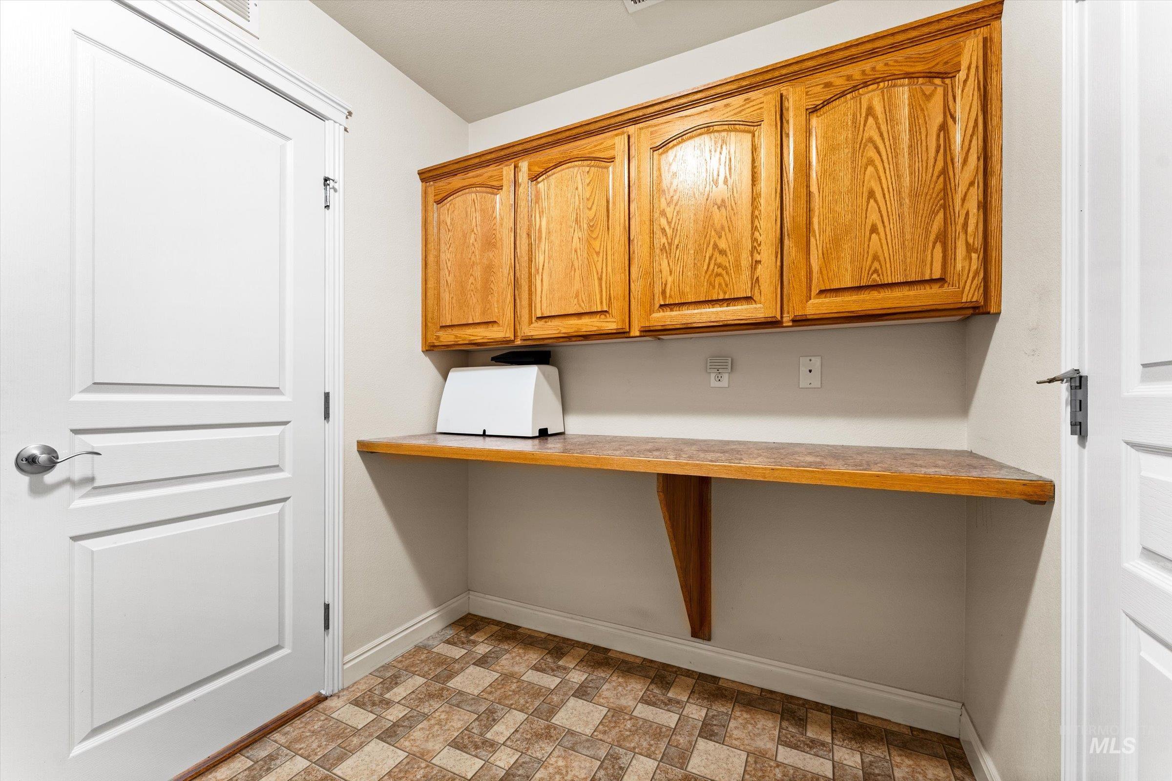 Unfurnished office with baseboards and brick patterned flooring