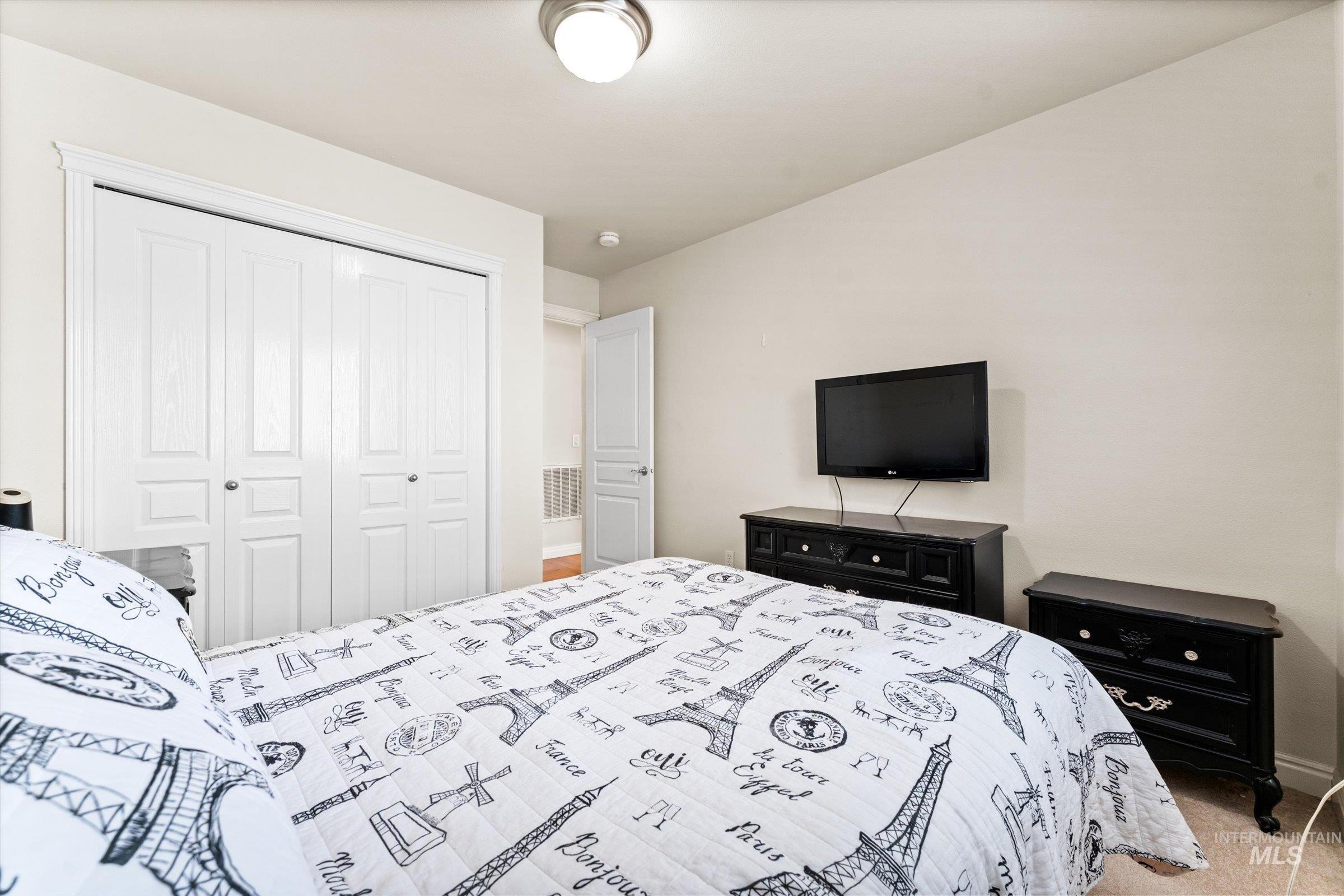 Bedroom with light carpet and a closet