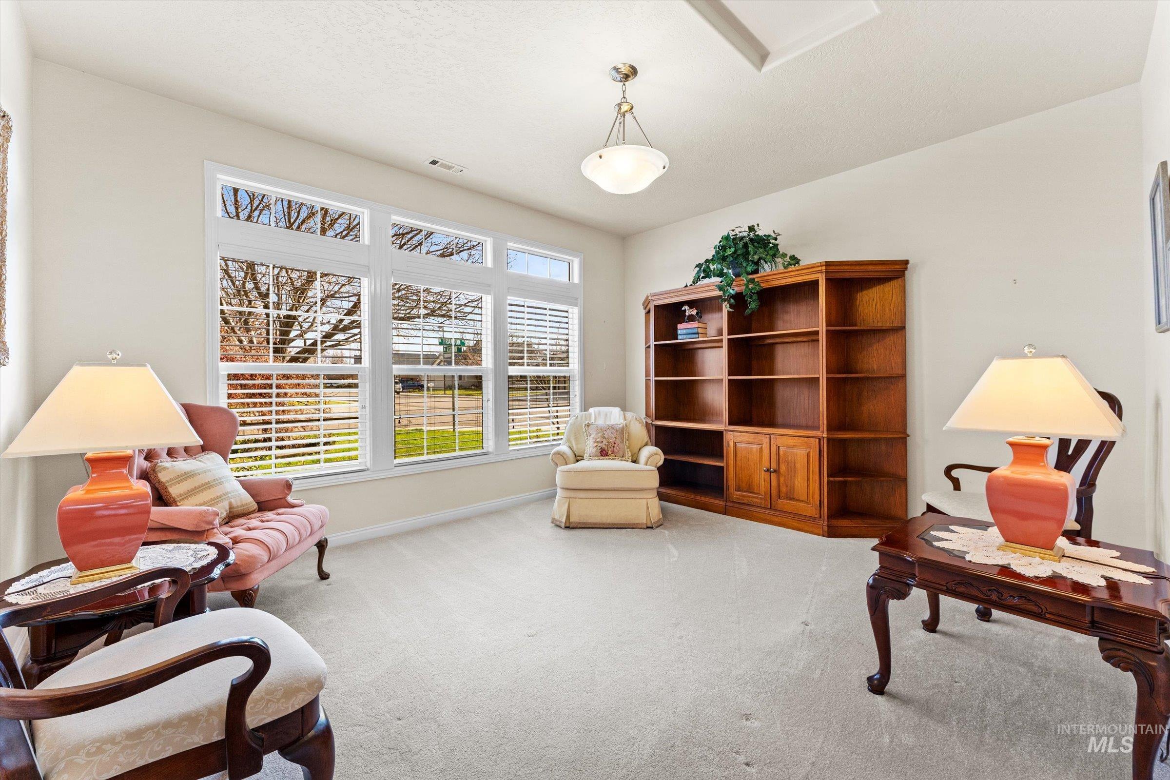 Living area featuring light carpet and baseboards
