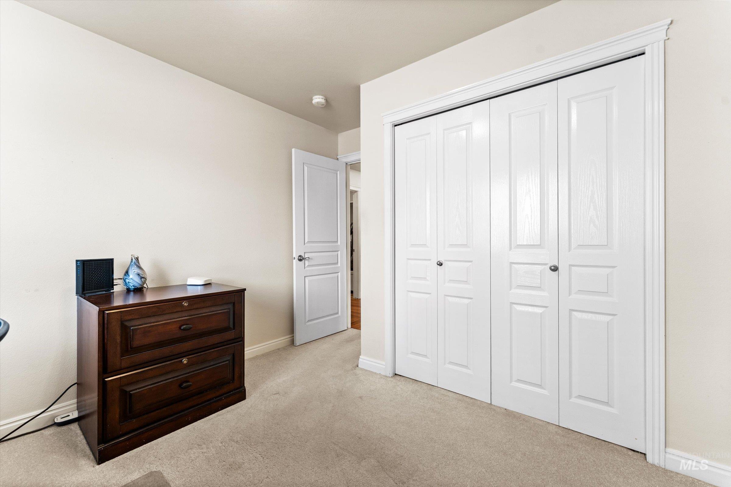 Bedroom featuring light carpet and a closet