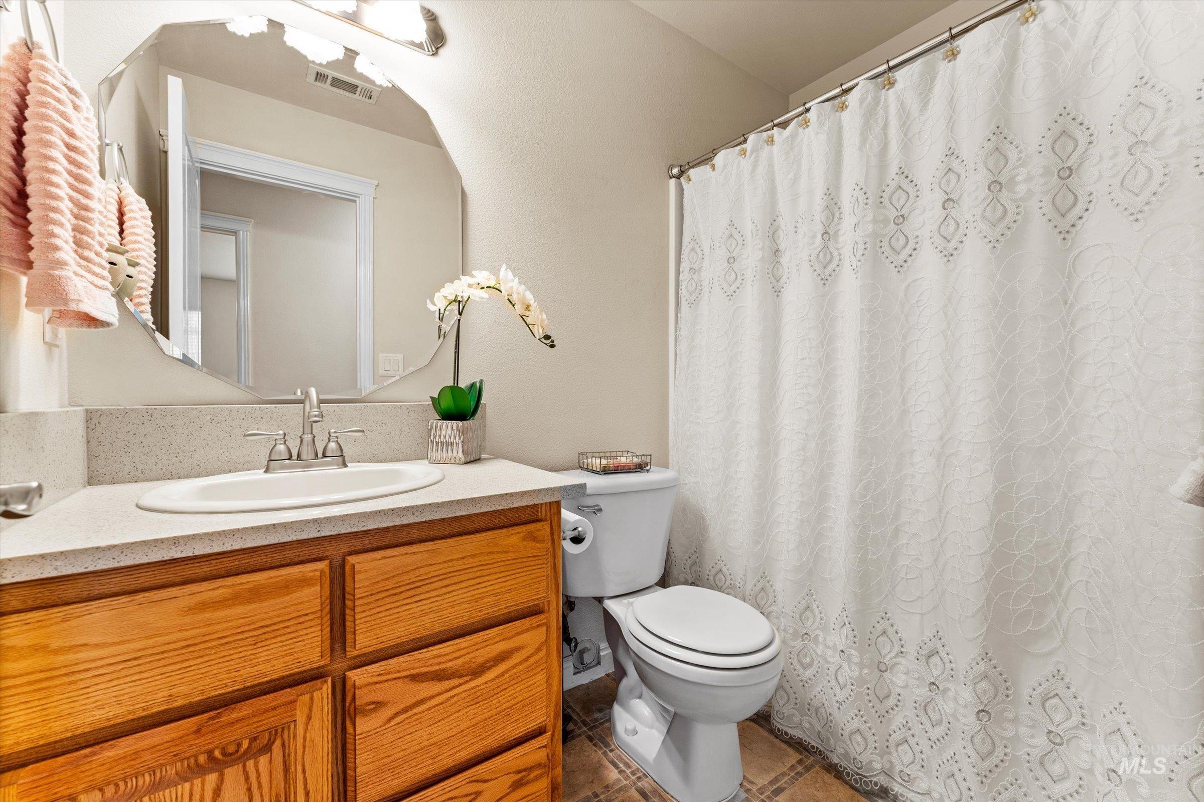 Bathroom with vanity, a shower with curtain, and tile patterned flooring