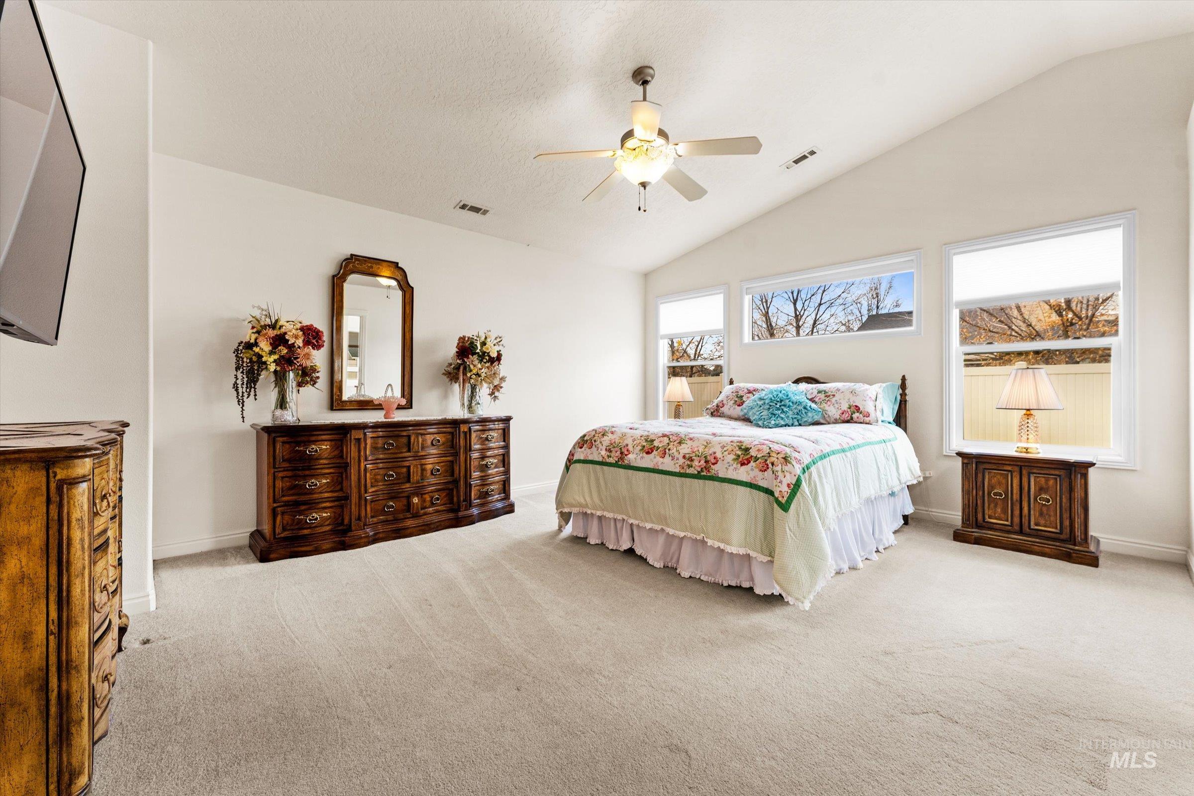 Bedroom featuring vaulted ceiling, carpet floors, and ceiling fan