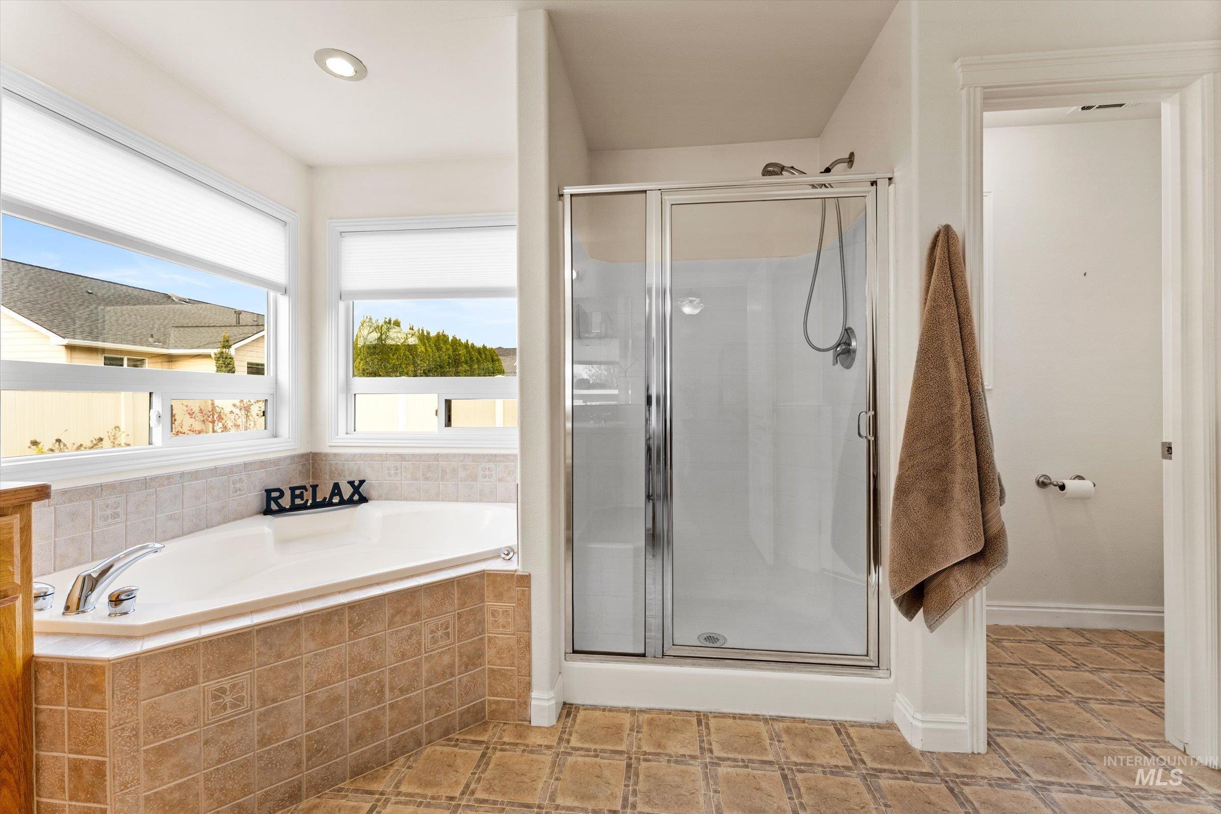 Full bathroom featuring a shower stall, a garden tub, and recessed lighting