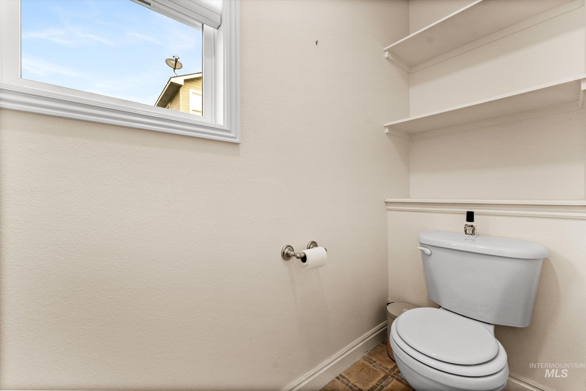 Half bath with toilet and baseboards
