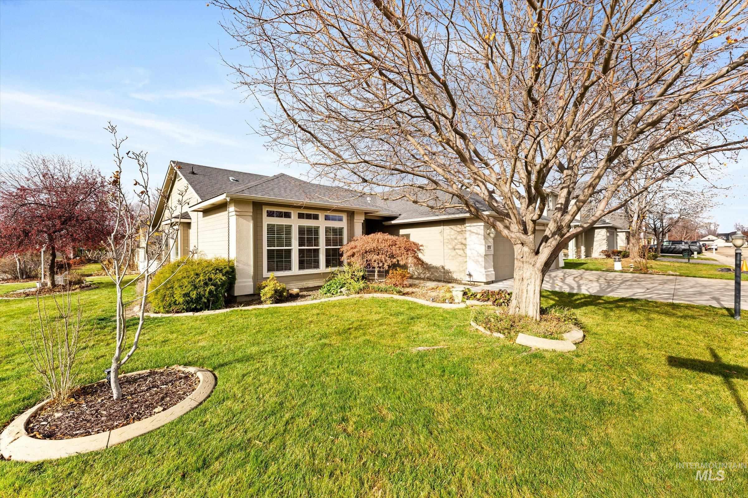 View of front facade featuring driveway, a front lawn, and an attached garage