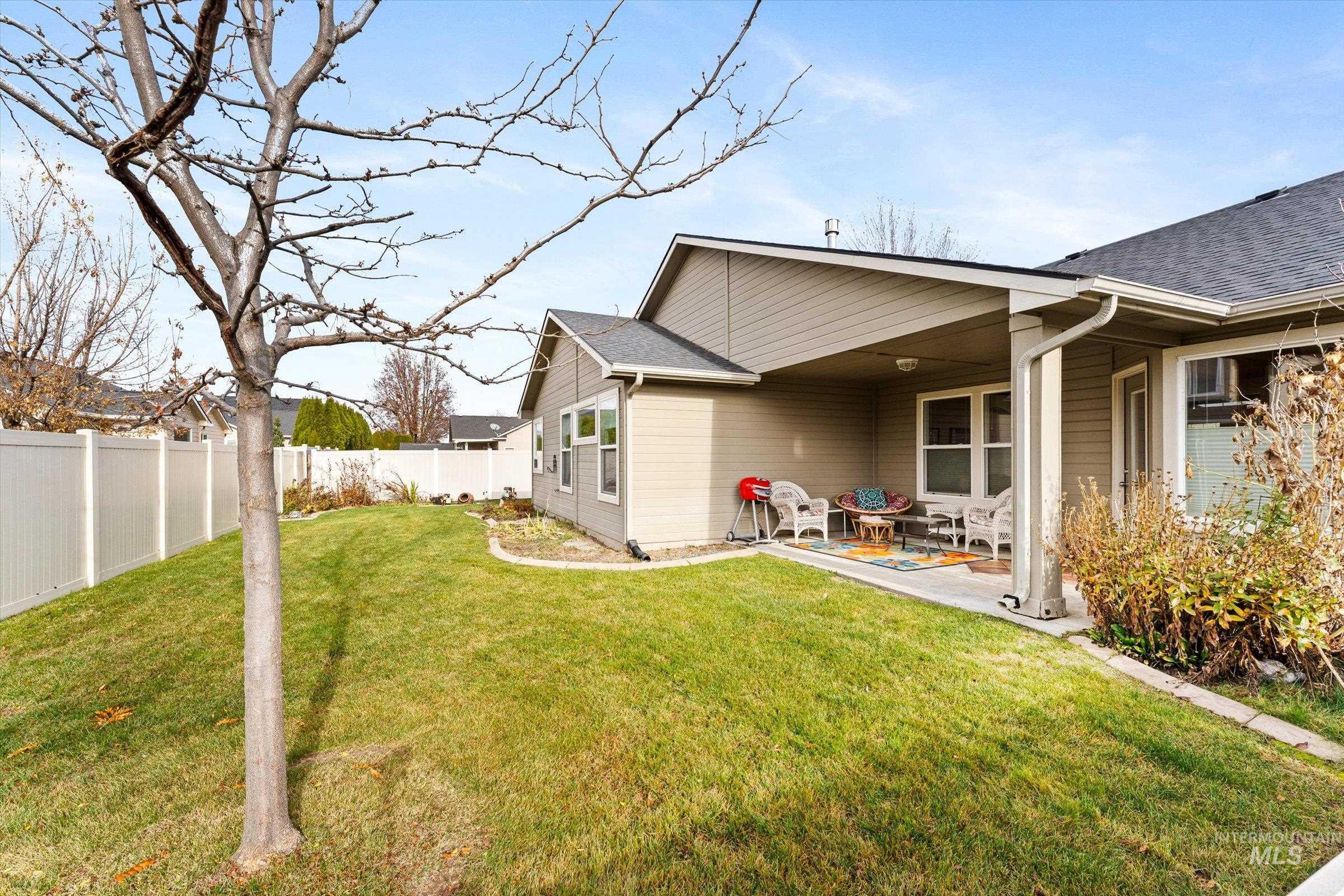 Rear view of house featuring a fenced backyard, a shingled roof, and a patio area