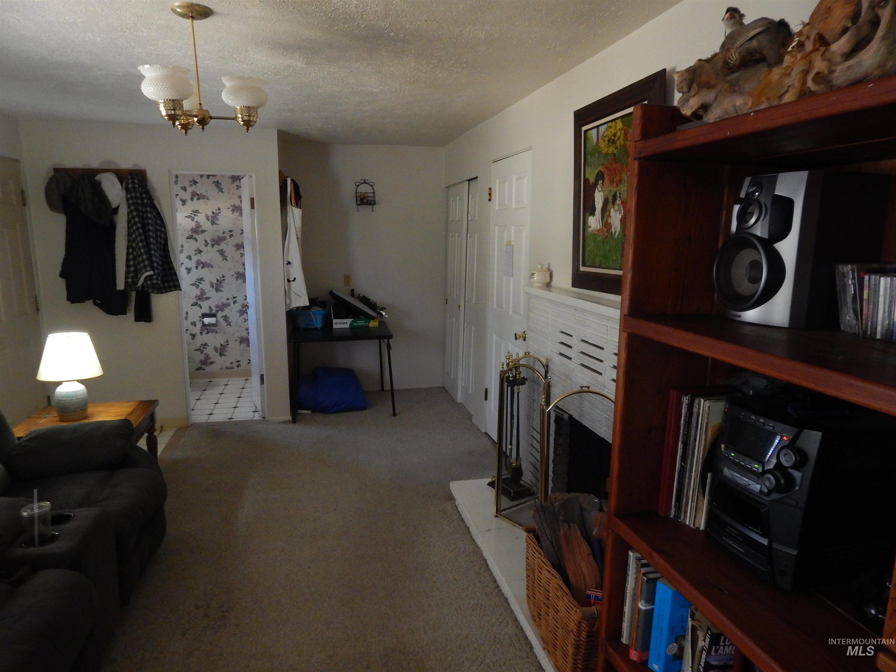 Carpeted living room with a textured ceiling and a chandelier