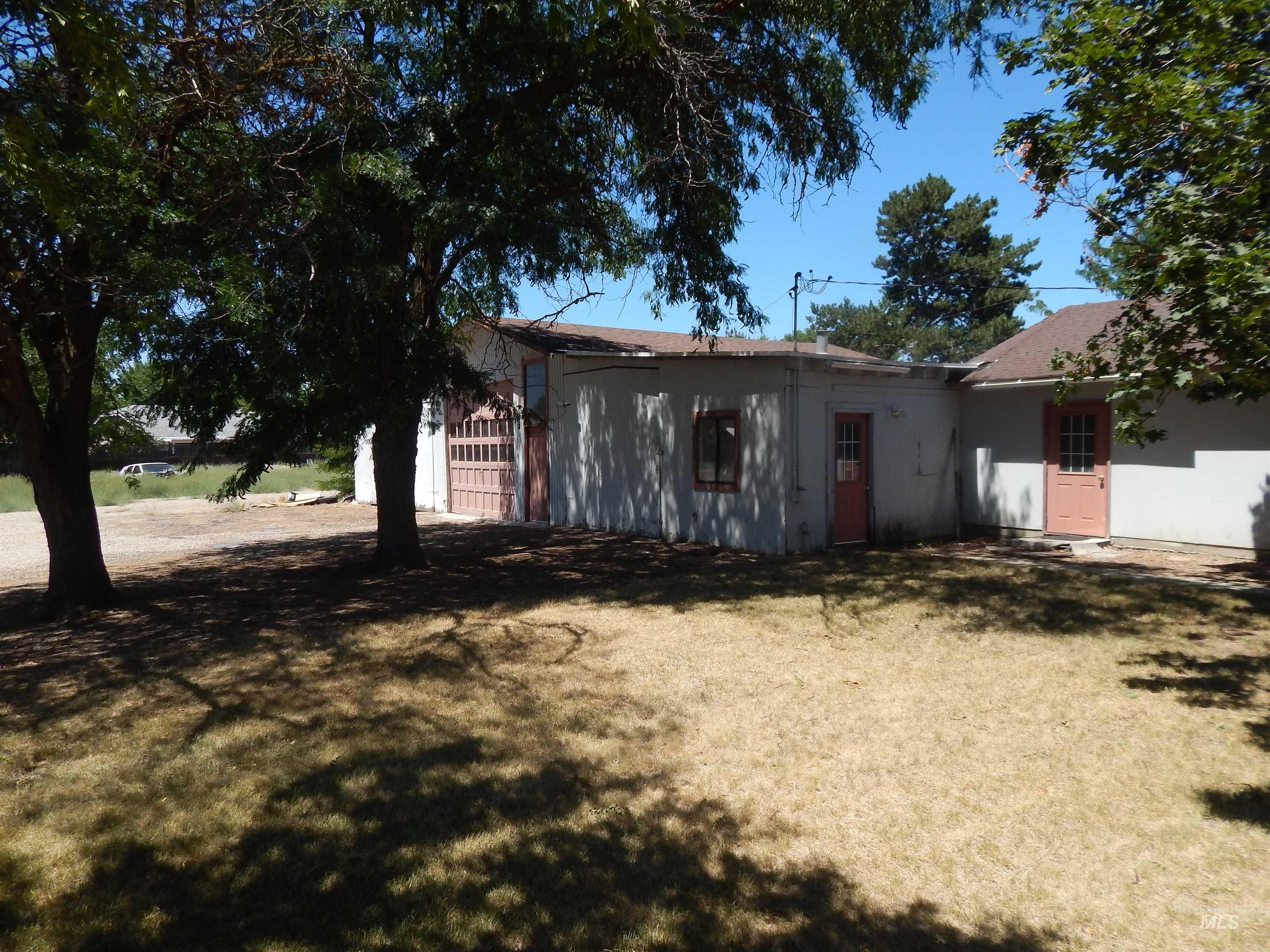 View of front of house with stucco siding, a front yard, and a garage