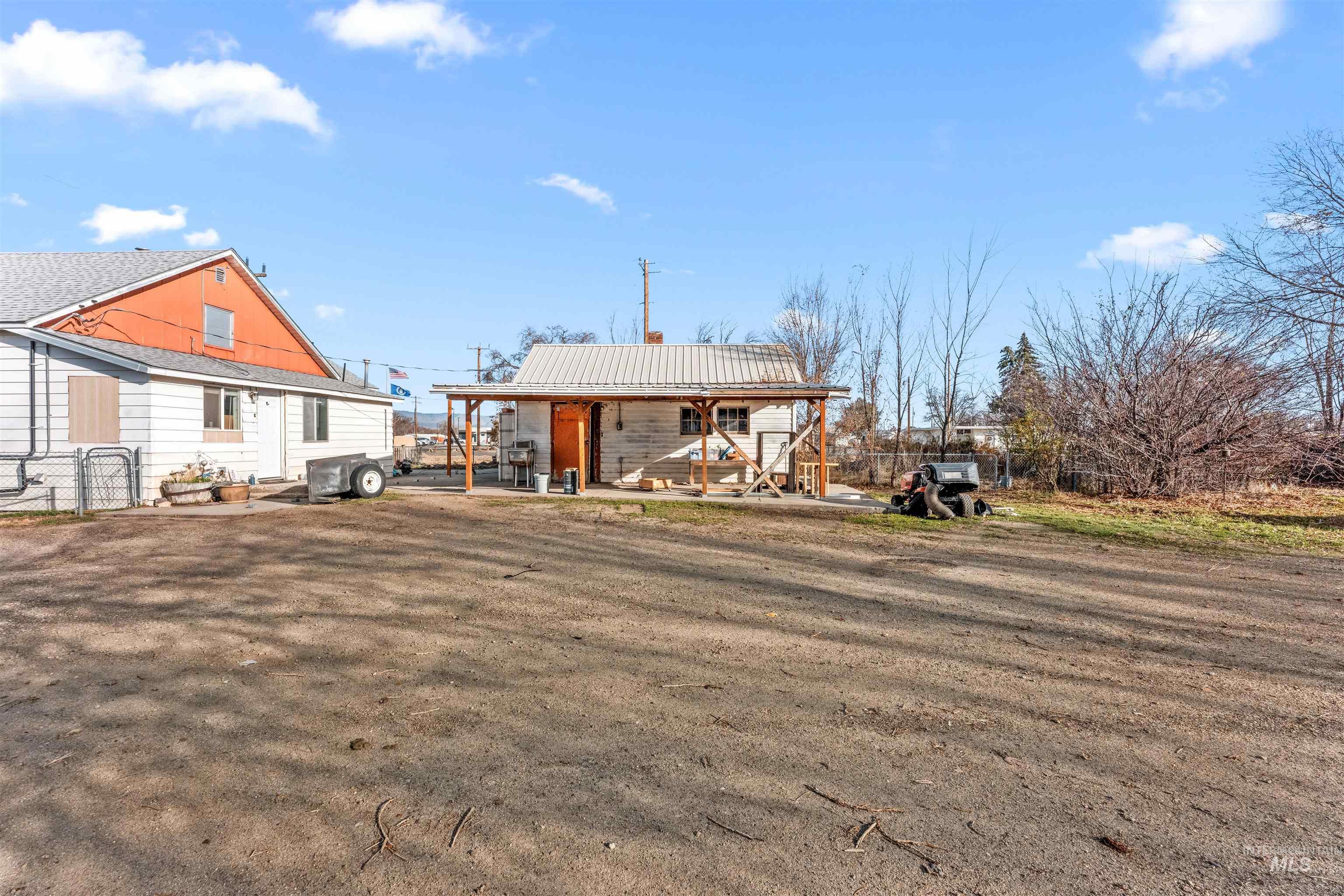 Back of house with a chimney and a metal roof