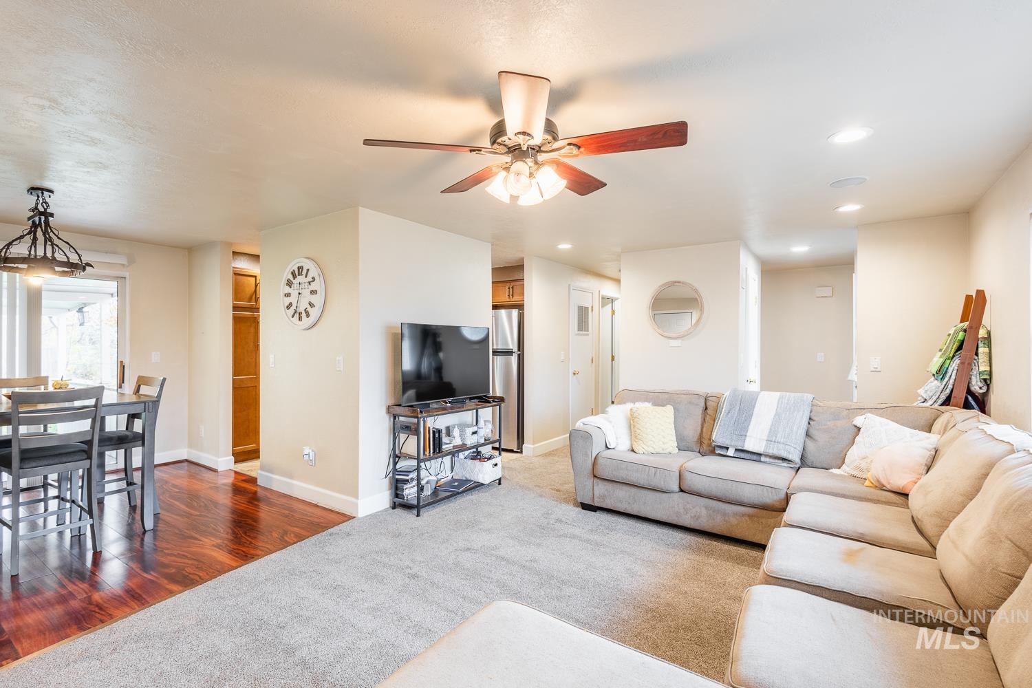 Living area with recessed lighting, carpet, ceiling fan, and wood finished floors