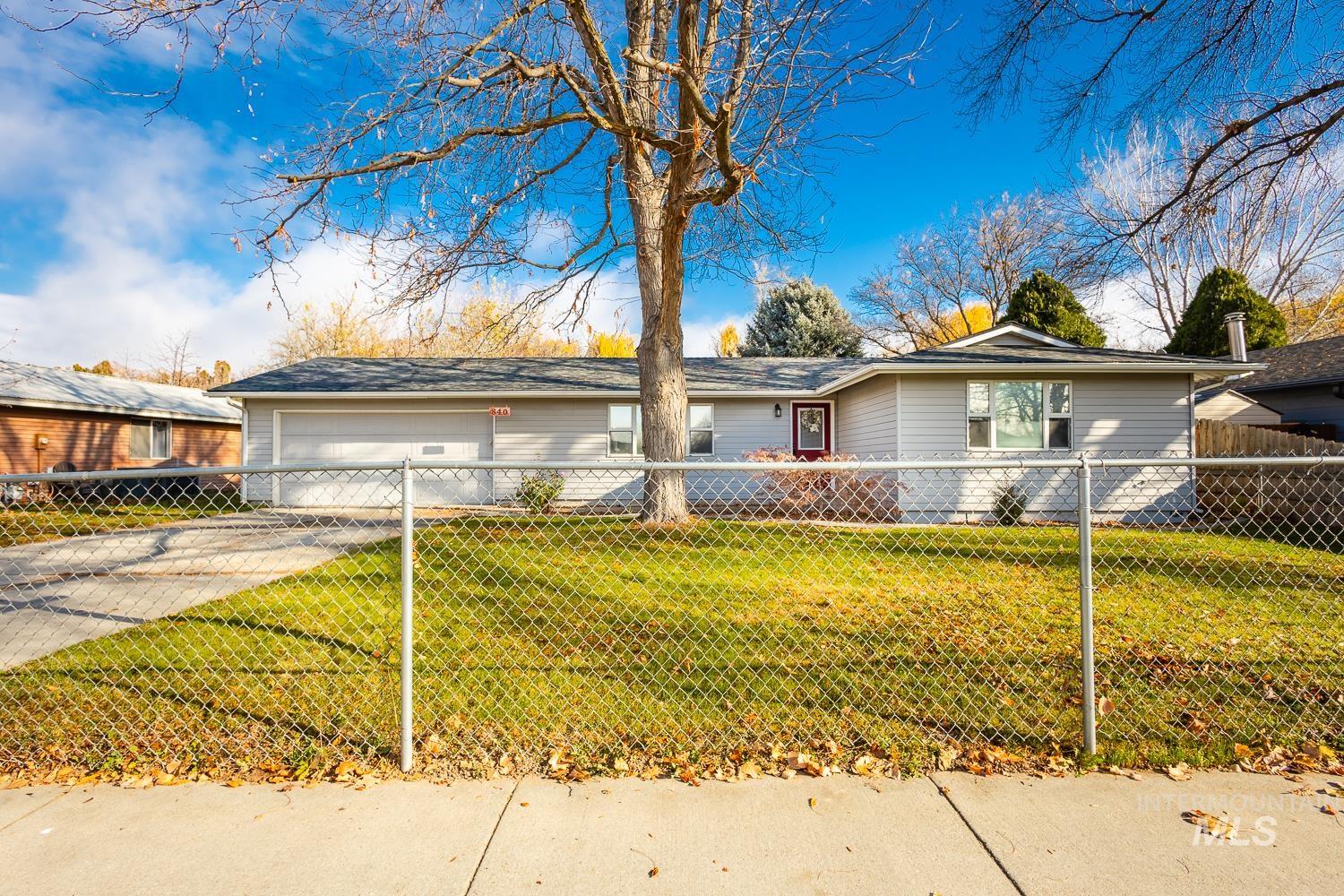 Ranch-style home featuring driveway and a fenced front yard
