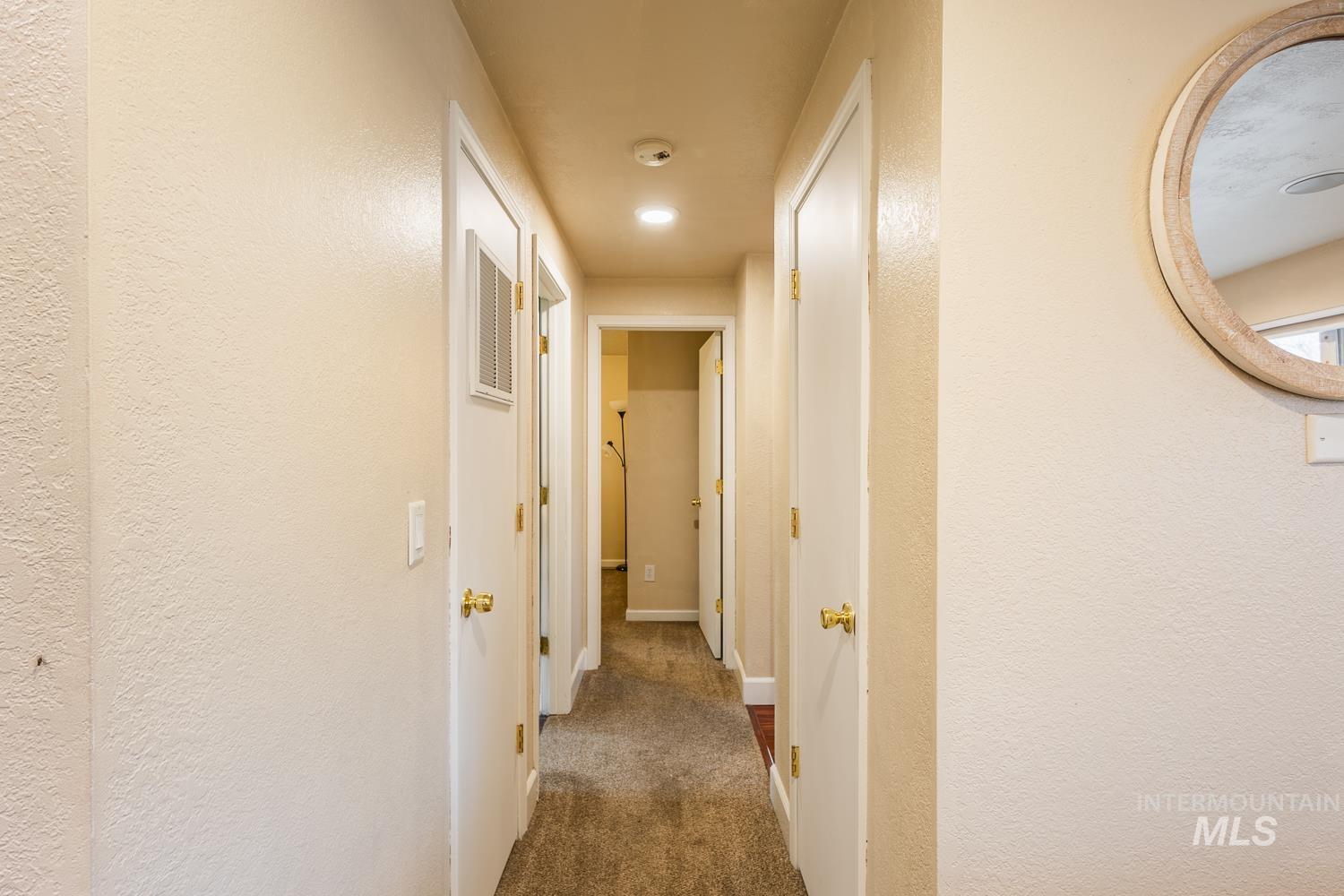 Hallway featuring a textured wall and carpet flooring