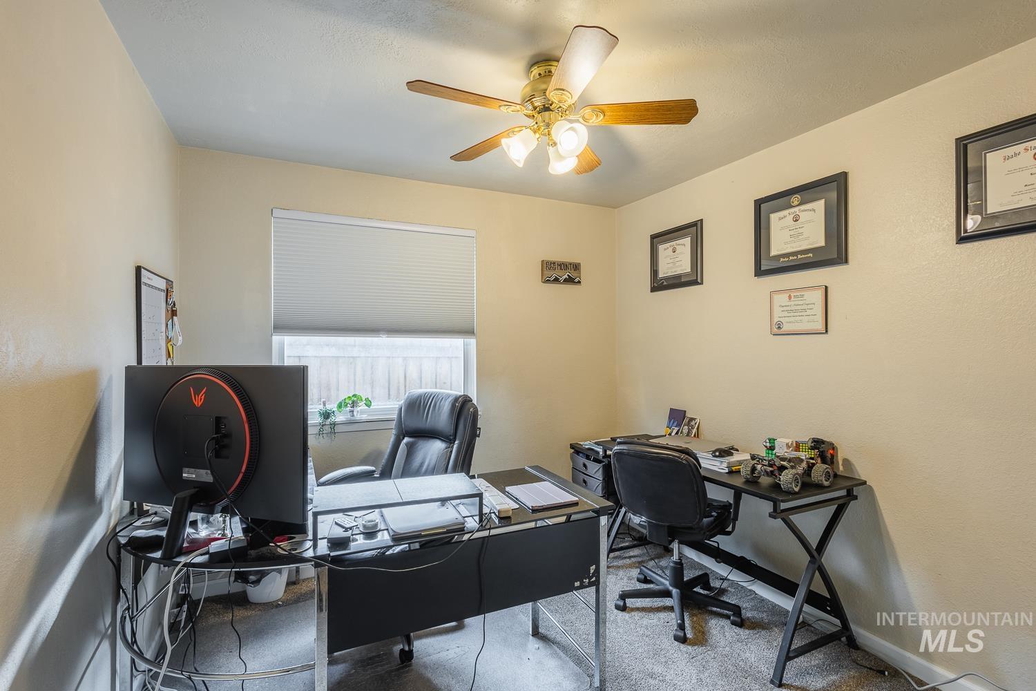Home office with carpet and ceiling fan