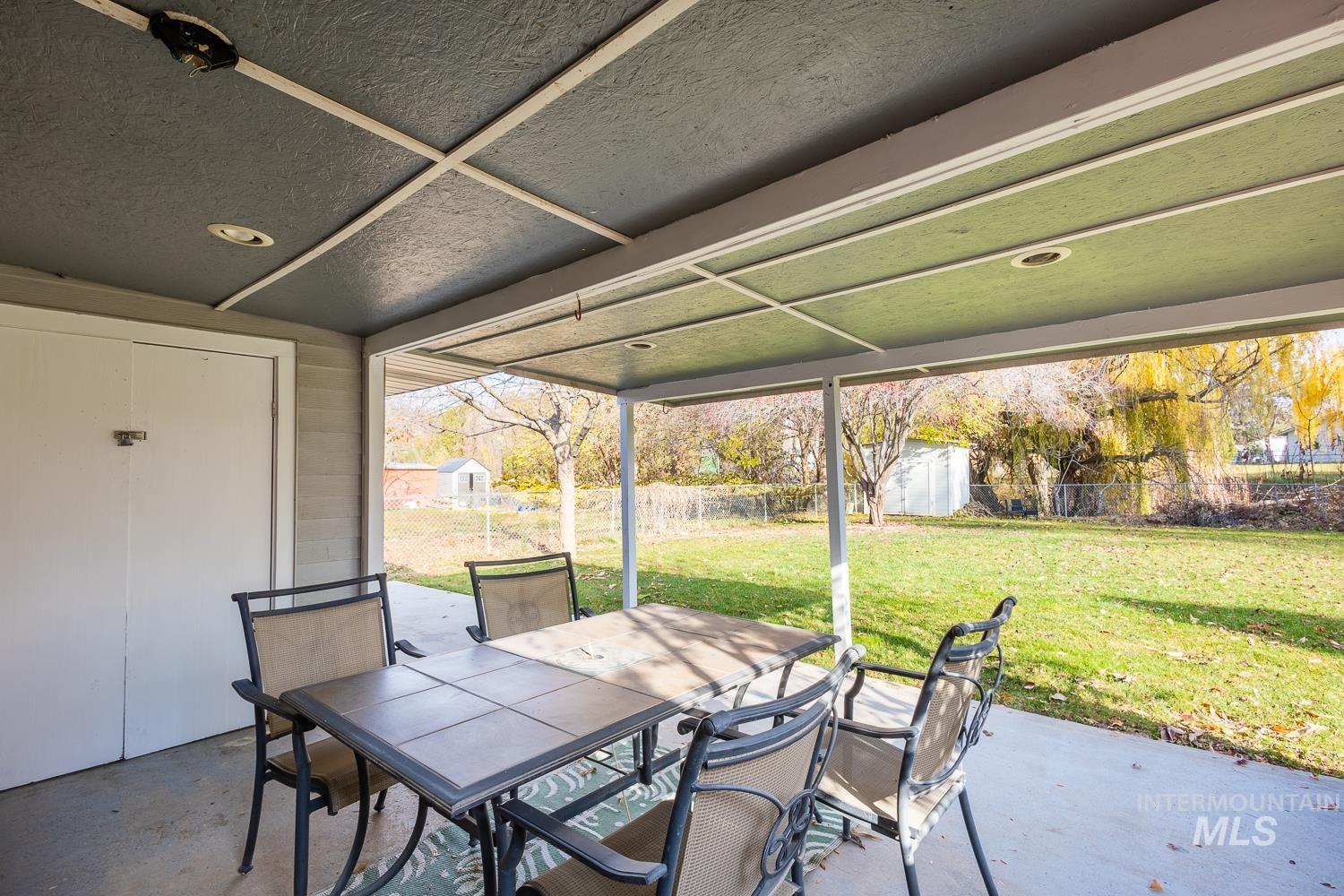 Fenced backyard featuring outdoor dining area, a patio, and a storage shed