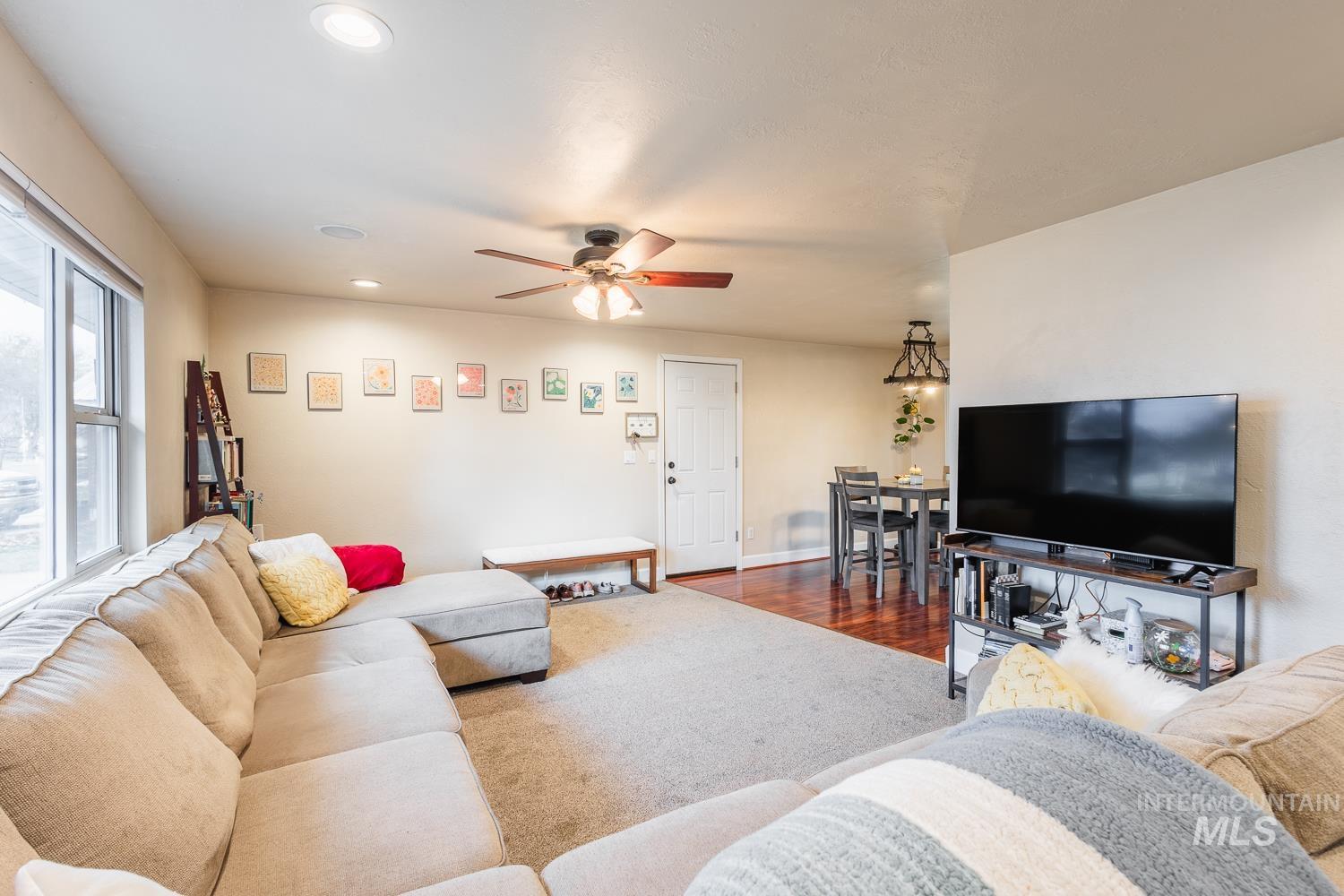Living area featuring recessed lighting, dark wood-style flooring, and a ceiling fan