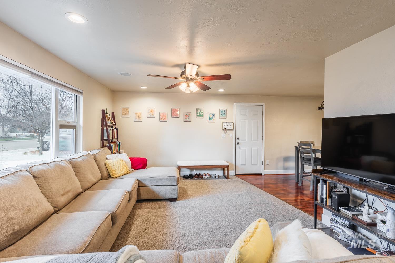 Living area featuring recessed lighting, a ceiling fan, dark carpet, and dark wood-style floors