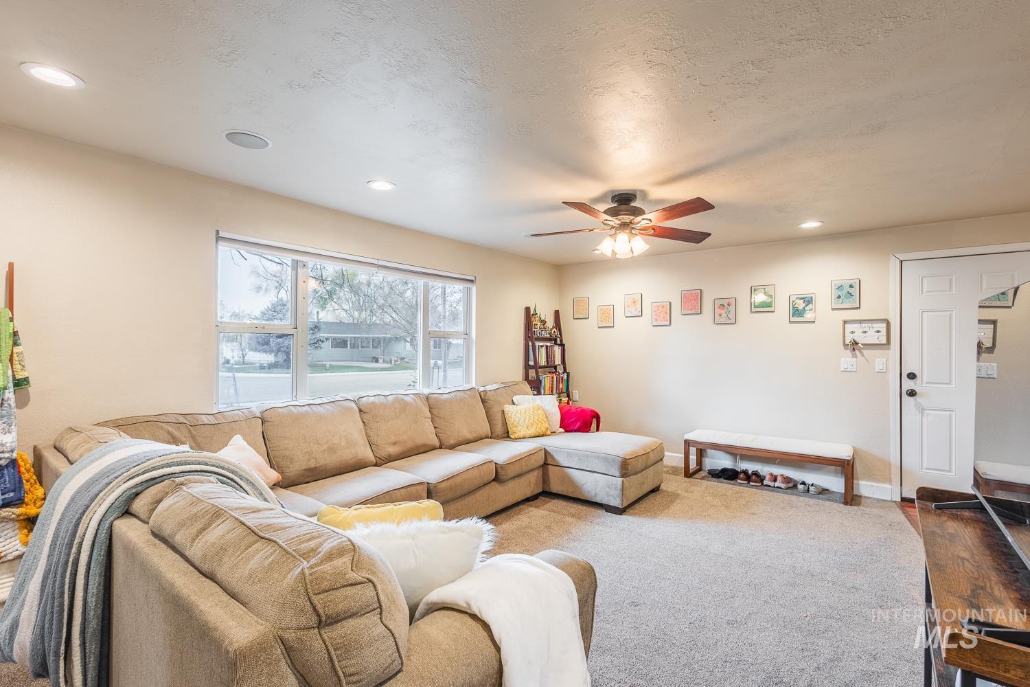 Living area featuring recessed lighting, ceiling fan, and a textured ceiling
