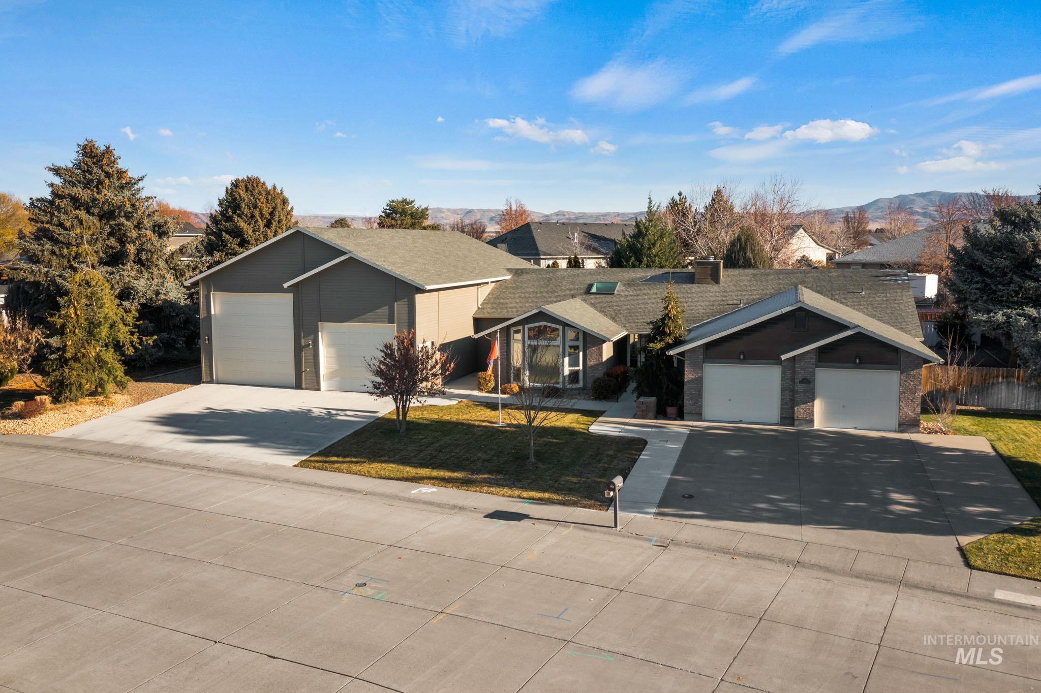 Ranch-style home featuring driveway, a garage, and a front lawn