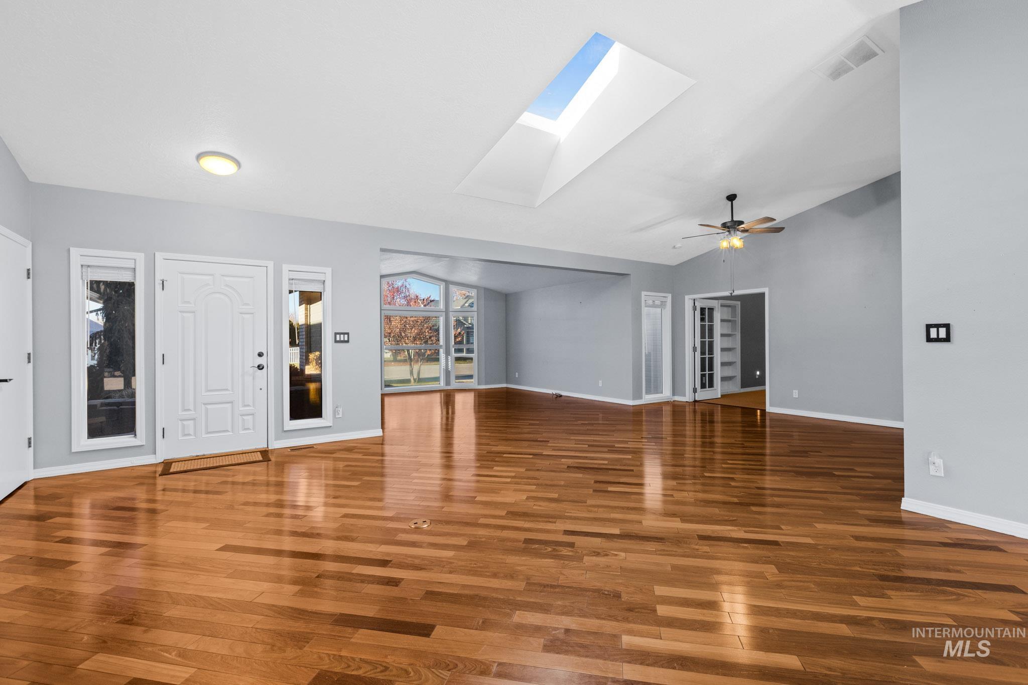 Foyer entrance featuring vaulted ceiling, a skylight, hardwood / wood-style floors, and a ceiling fan