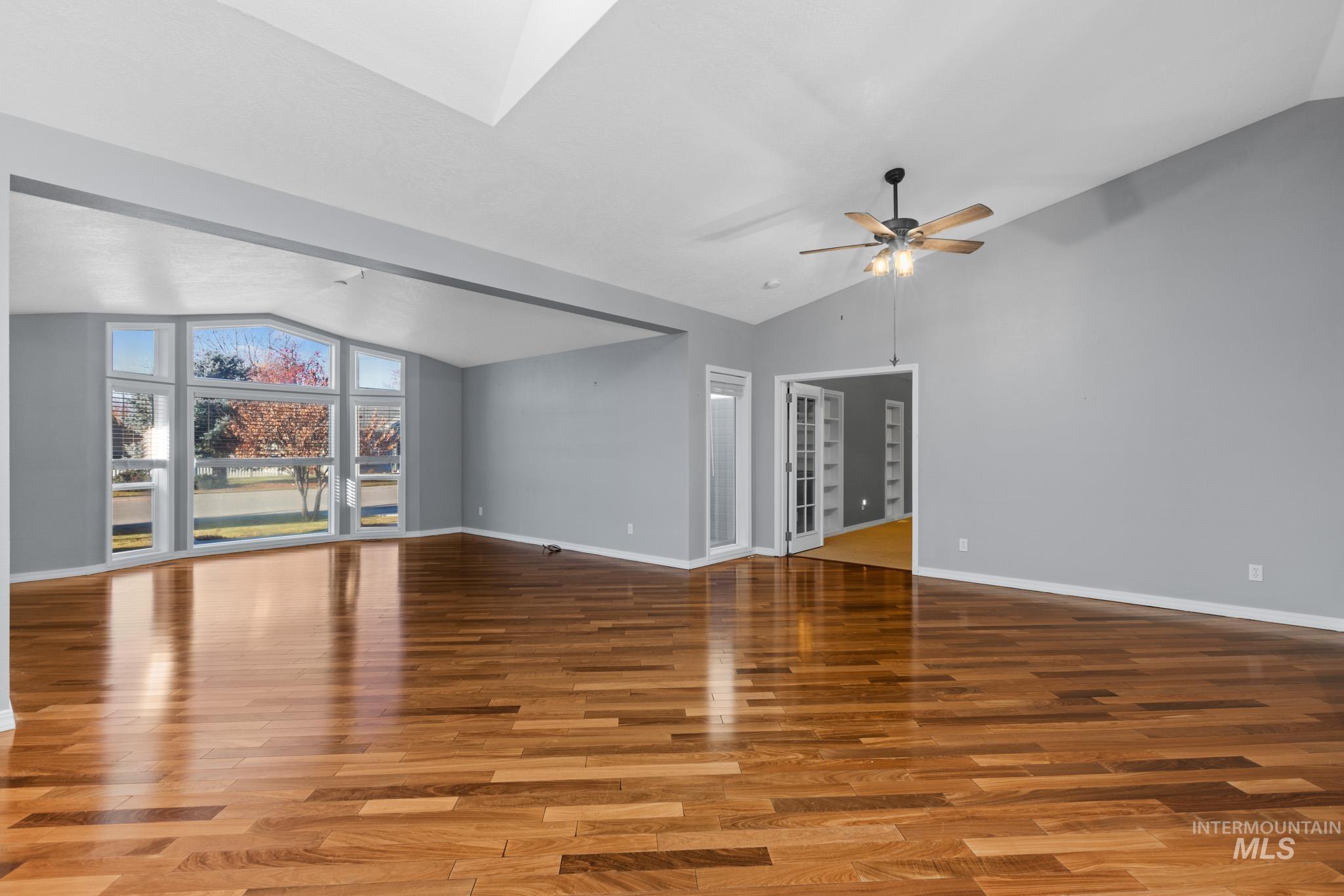 Unfurnished living room featuring lofted ceiling and light wood-style floors