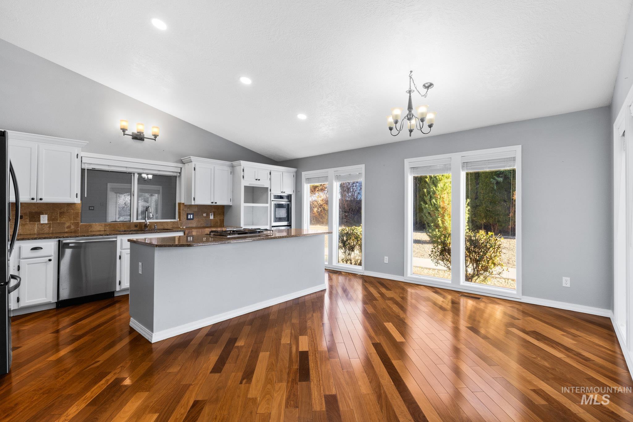 Kitchen featuring white cabinetry, a chandelier, a kitchen island, recessed lighting, and stainless steel appliances