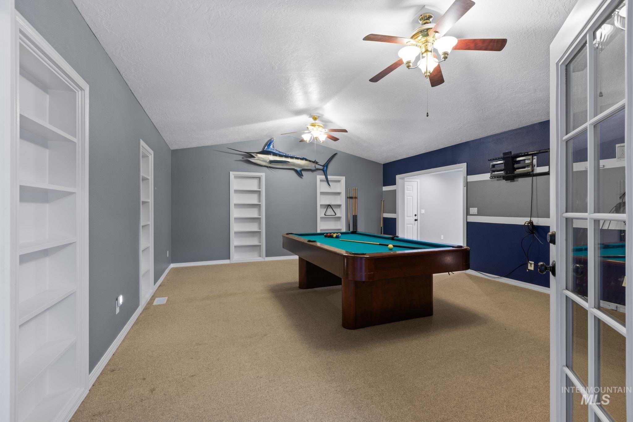 Playroom featuring lofted ceiling, built in shelves, billiards table, a ceiling fan, and light colored carpet
