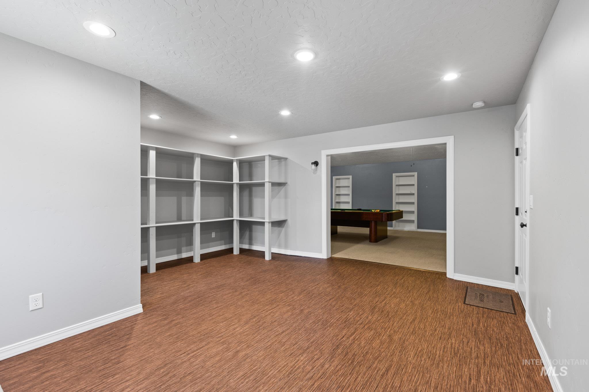 recessed lighting, a textured ceiling, and dark wood-type flooring